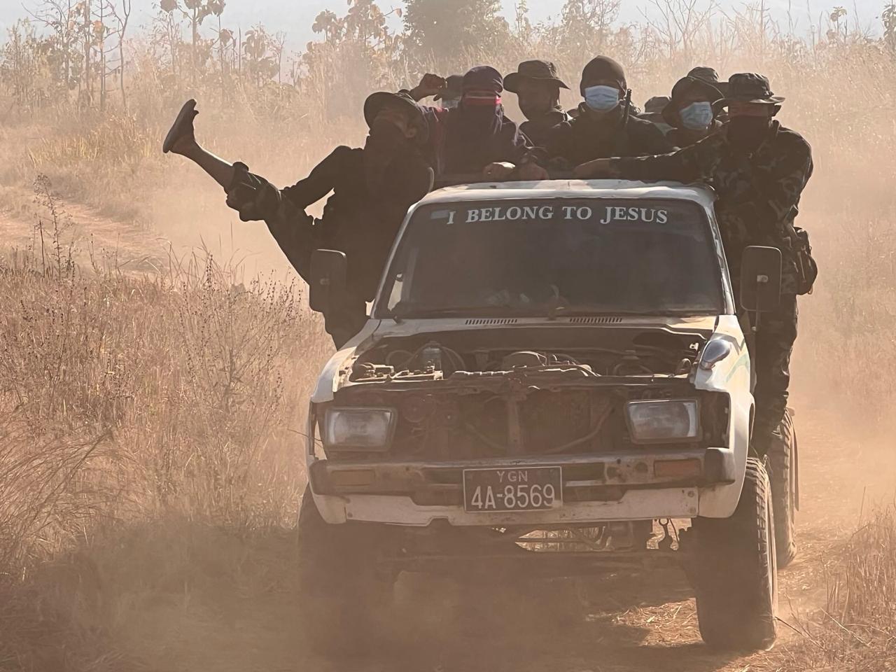 Group riding in a damaged pickup truck on a dusty road during a humanitarian mission in Karenni State.